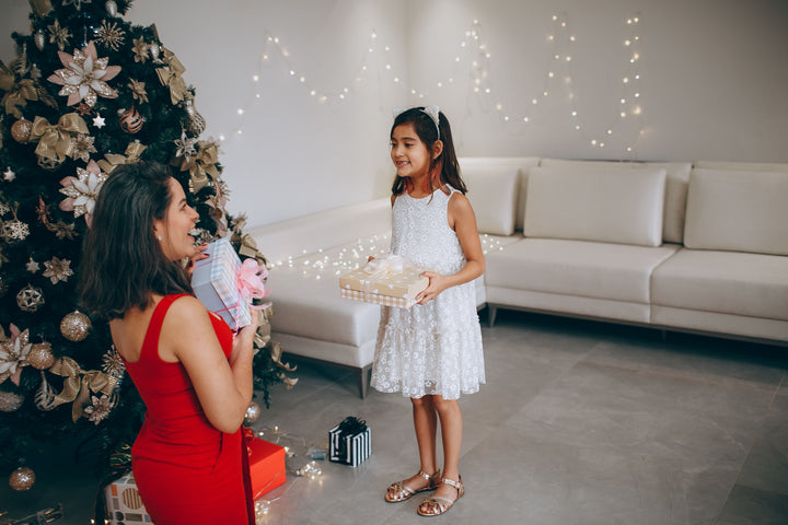 Filipino heritage gift for parents, child giving wrapped gift to mother at Christmas, pasalubong tradition